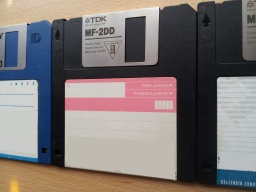 A row of 3 off floppy disks 3.5 inches awaiting Word file extraction. The disks are photographed at an angle with only part shown of disks 1 and 3. 